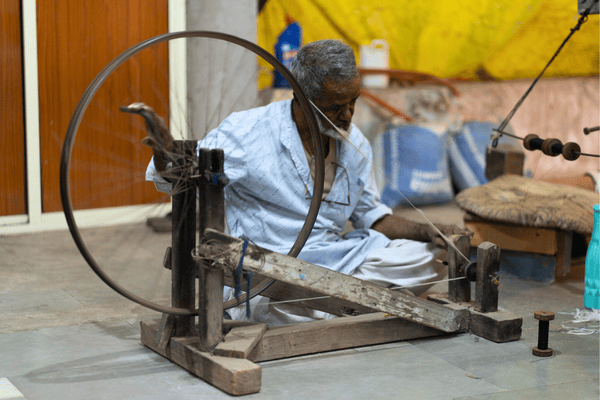 Artisan operating traditional paga spinning wheel for Himroo weaving Aurangabad Himroo Factory